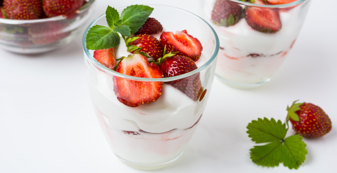 Das Foto zeigt ein Glas mit Erdbeer-Schicht-Dessert gefüllt.