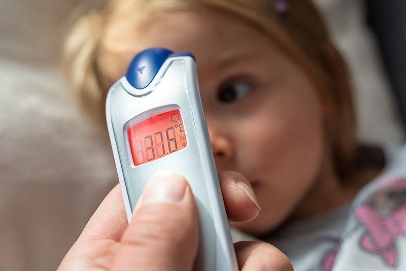 Eine Mutter kümmert sich um ihr fieberndes Kind