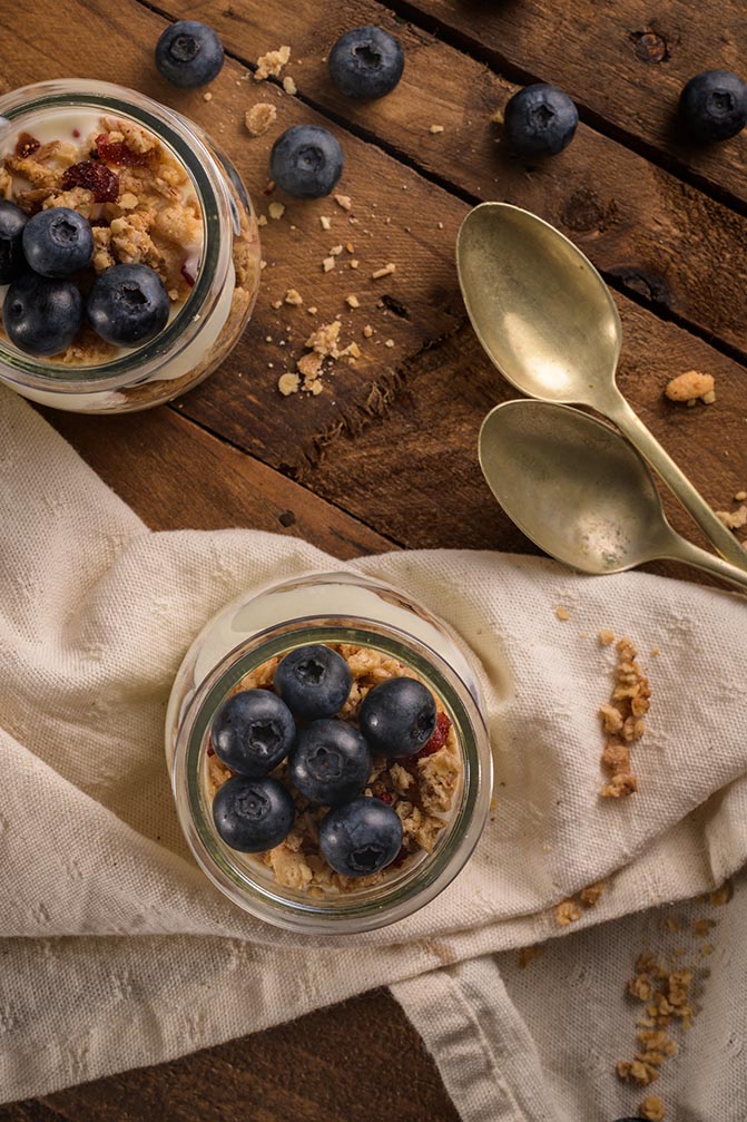 Zwei Gläser mit einer Blaubeer-Speise auf einem schönen Holztisch