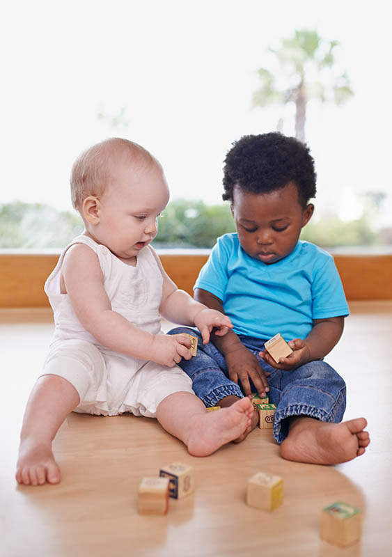 Zusammen Lernen und Wachsen, zwei Babys beim gemeinsamen Spielen mit Bauklötzen