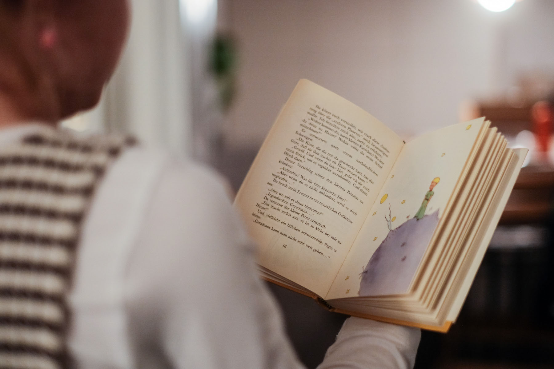 Ein Kind hält ein Buch lesend in den Händen