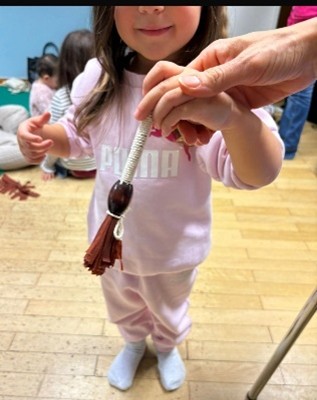 Ein Kind hält einen kleinen Besen in der Hand