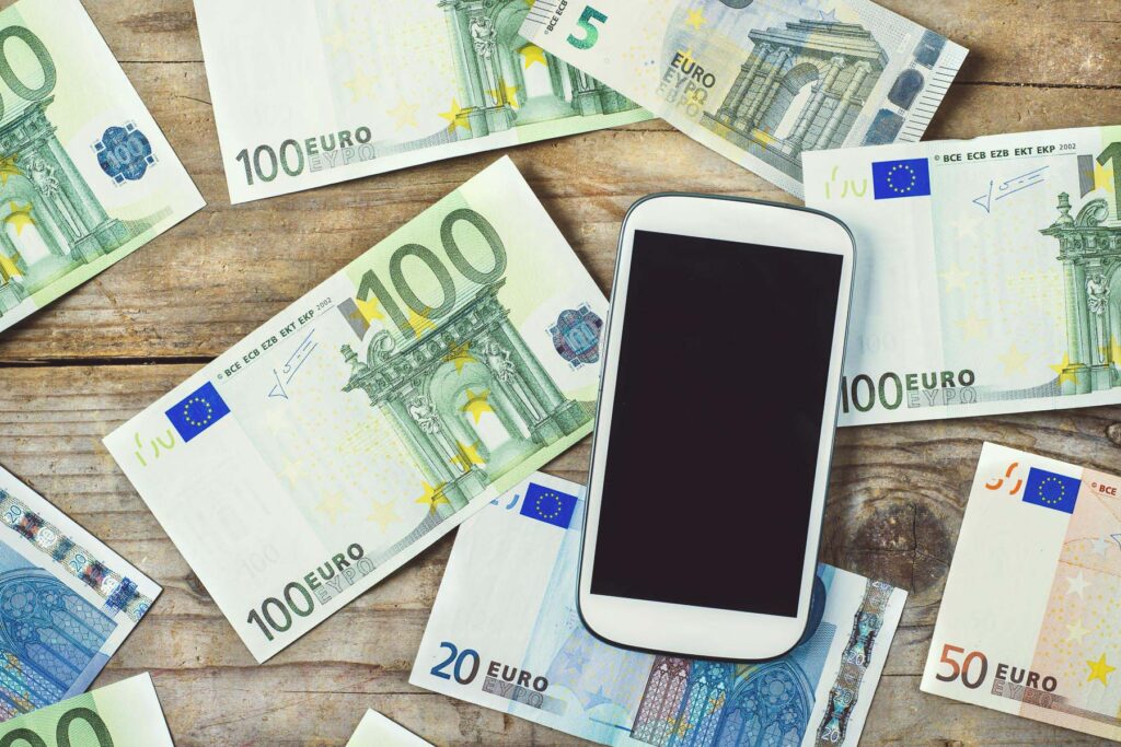 Ein Tisch mit Geldscheinen und einem Smartphone